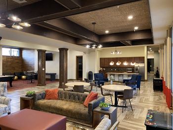 A large room with a couch, chairs, and a dining table at The Retreat Apartment Homes in North Dakota 58801
